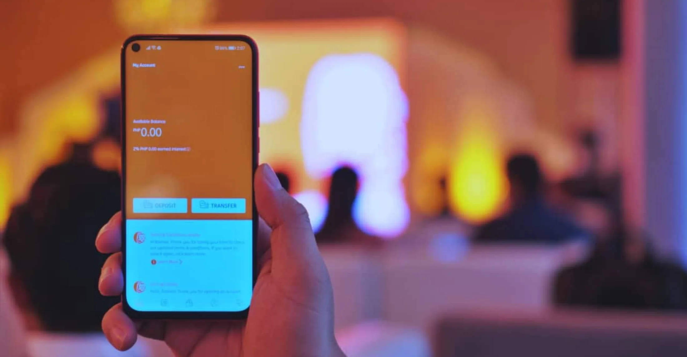 Hand holding a phone running the ING mobile banking app account screen at a launch event in the Philippines